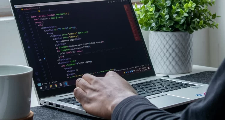 view of a person programming on a laptop